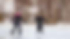 Två kvinnor som åker skridskor på isen.