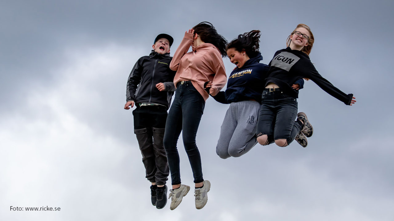 Fyra ungdomar som hoppar av glädje.