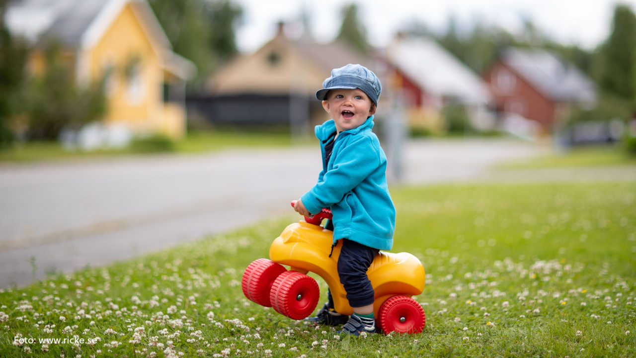 Litet barn på en leksaksbil.