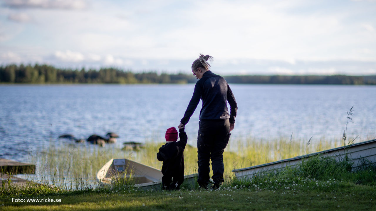 Barn och kvinna på väg ner till sjön.