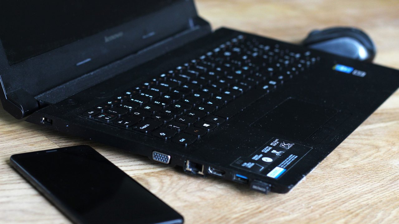 Bärbar dator och mobiltelefon på ett bord.