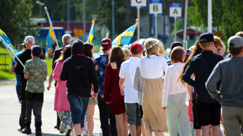 Elever som går i tåg. Ryggarna mot kameran.