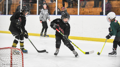 Barn som spelar hockey.