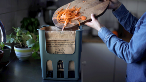 Morotsskal på väg ner i matavfallspåse.