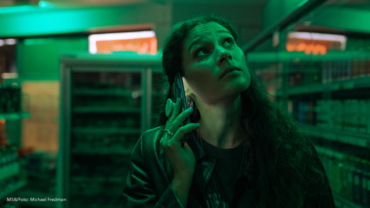 Kvinna i tom butik med blinkande lampor.