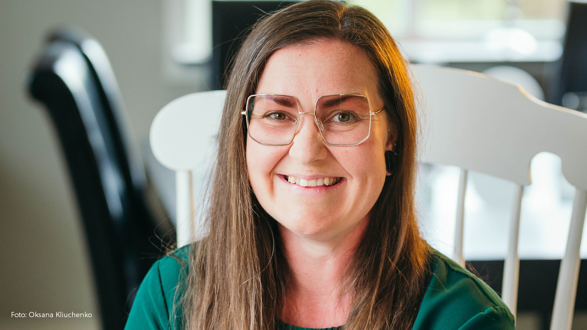 Porträtt av glad kvinna i glasögon.