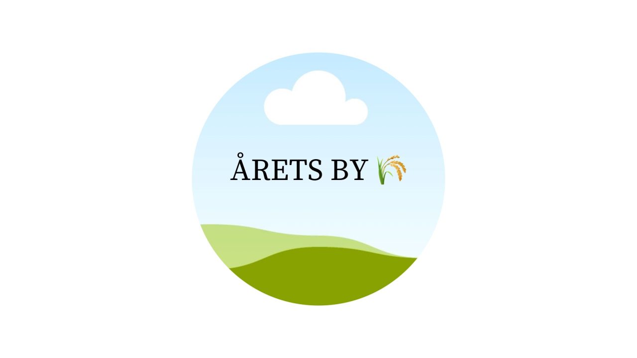 En rund cirkel med texten årets by och en havrekärve