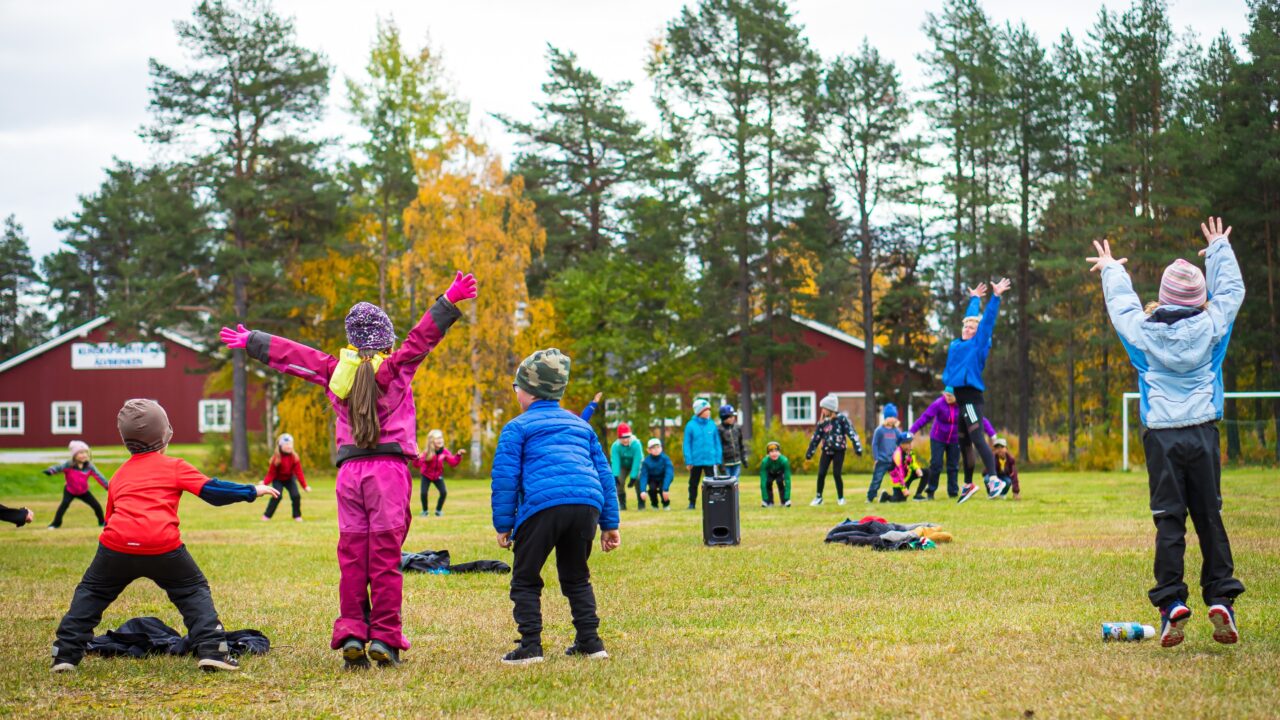 Barn som leker på en gräsyta i Sorsele